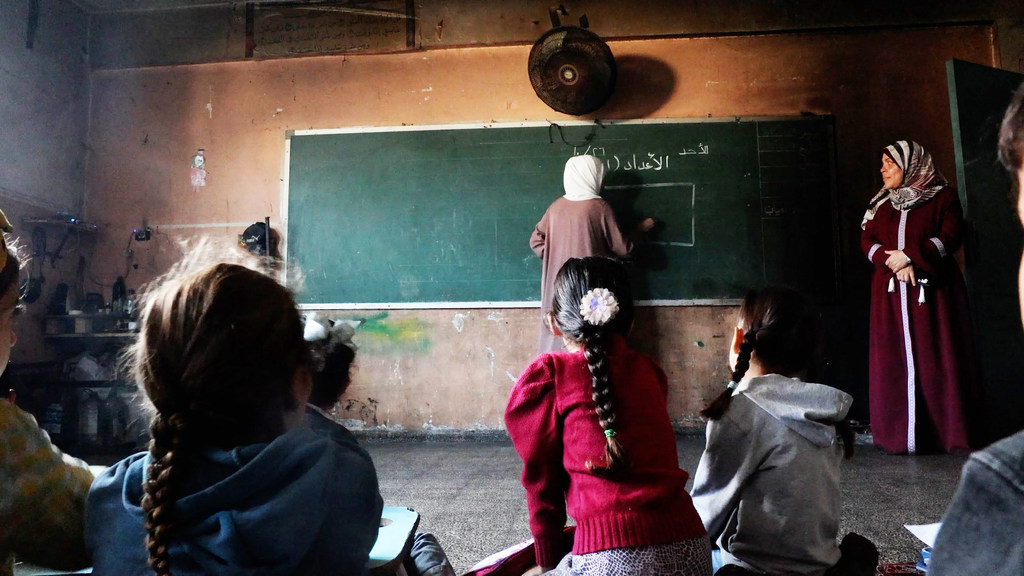Profesores interactuando con alumnos en la escuela primaria mixta Deir al-Balah, gestionada por la UNRWA.